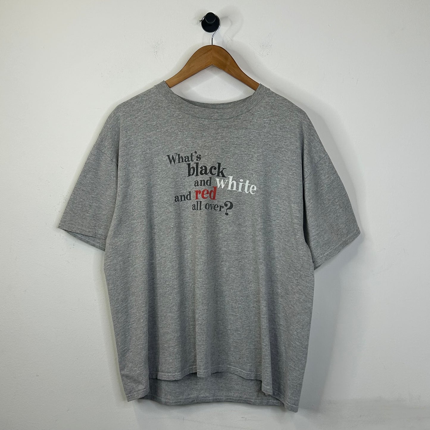 WHATS BLACK WHITE AND RED ALL OVER? TEE